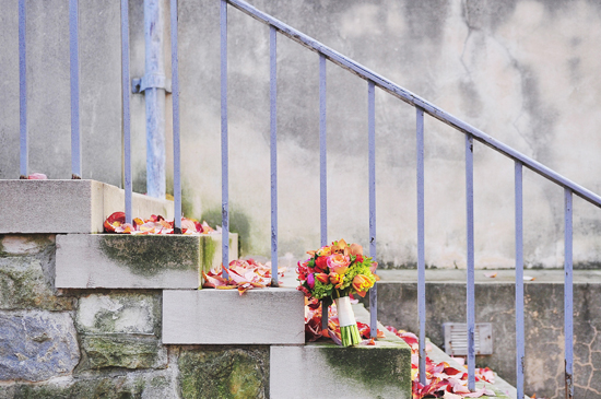 Wedding bouquet rests on stone steps with fallen leaves