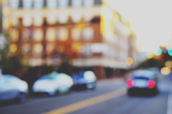 Blurry city street scene with cars and buildings