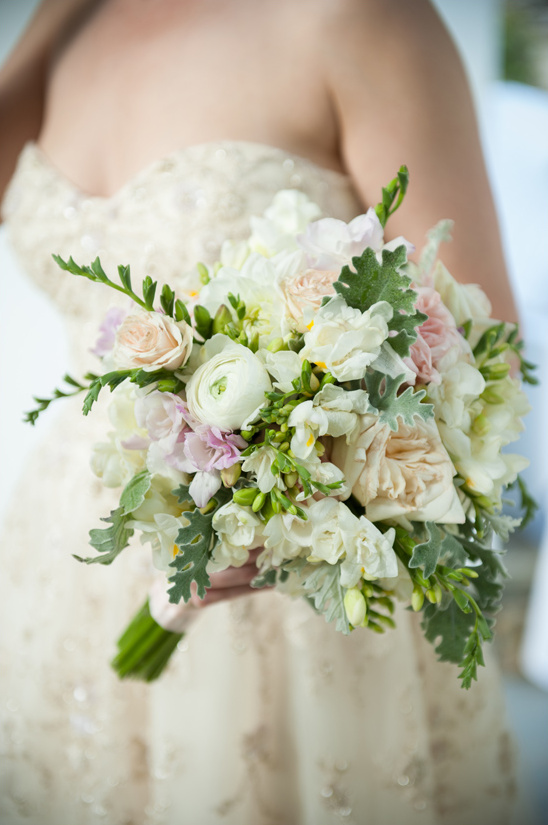 Bride holds a lovely bouquet of white and blush flowers