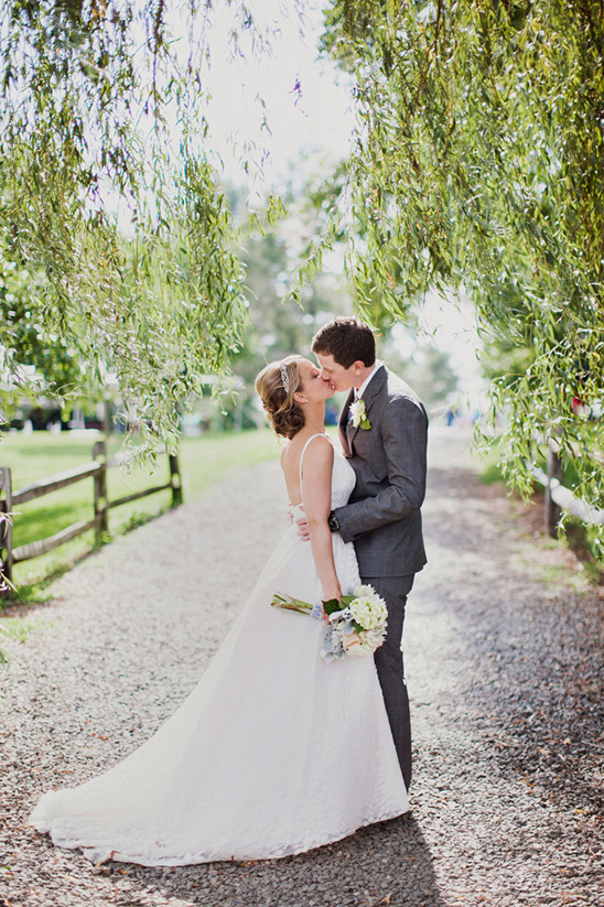 Romantic wedding couple kissing under trees