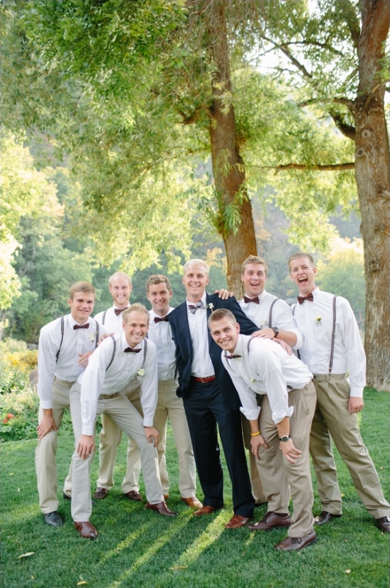 Groom and groomsmen outdoors in suspenders and bow ties