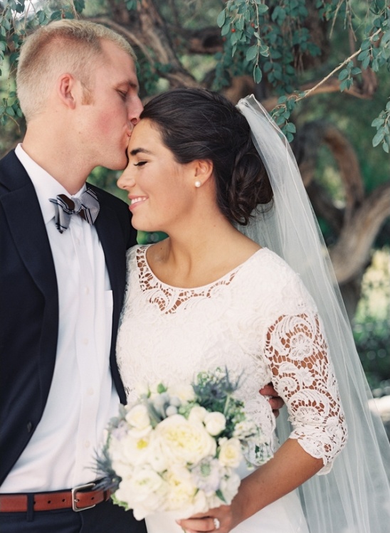 Newlyweds sharing a tender kiss on their wedding day