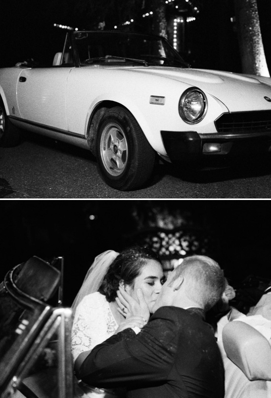 Bride and groom kiss by vintage convertible car