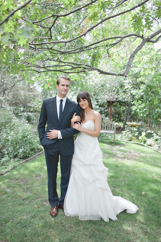 Couple in wedding attire under trees