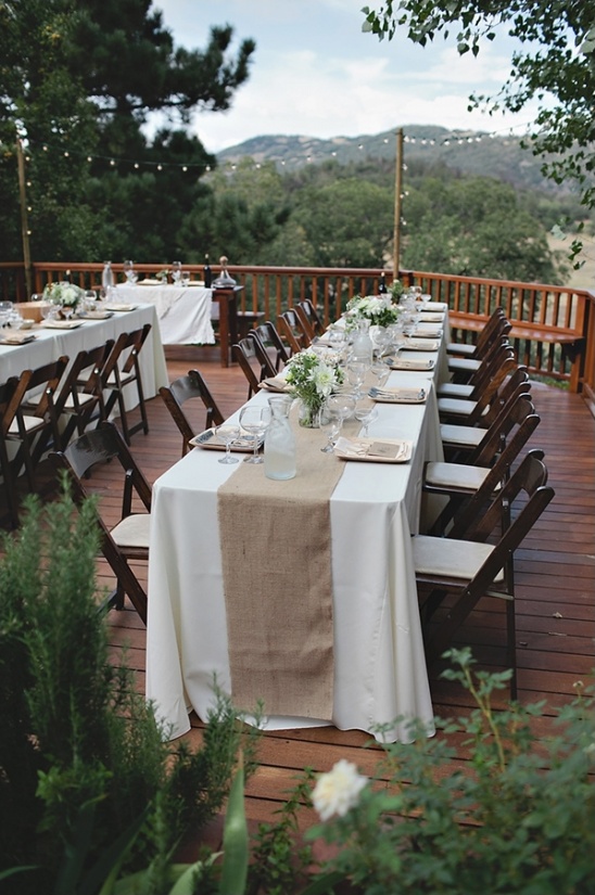 Outdoor wedding reception tables with burlap runner