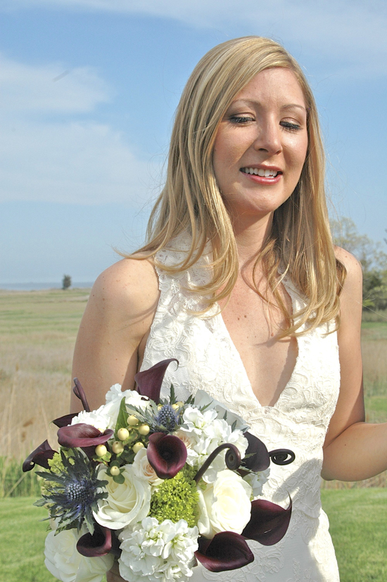 Bride smiling, holding a beautiful wedding bouquet
