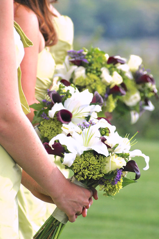 Bridesmaids hold elegant lily and calla lily bouquets