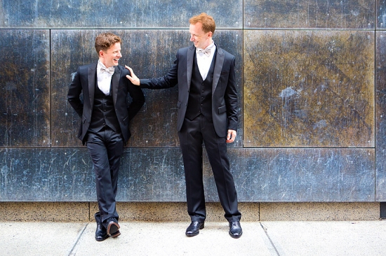 Two men in suits by a wall