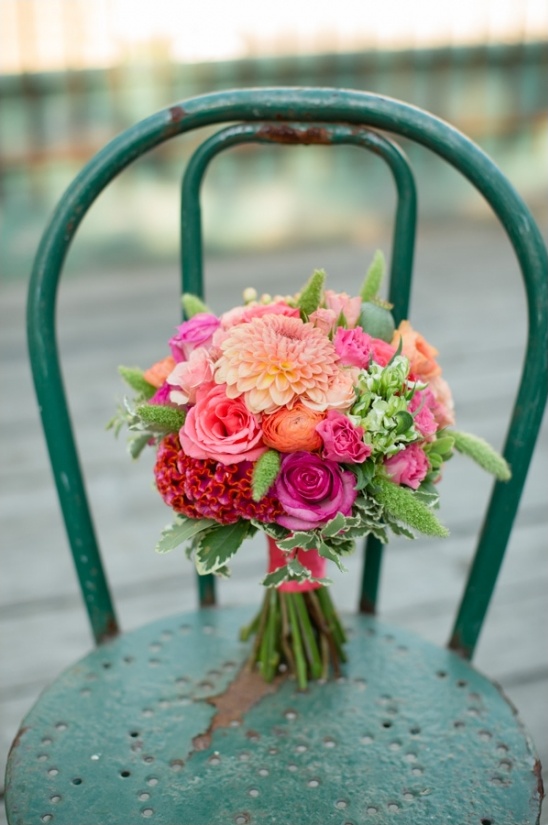 Colorful floral bouquet resting on vintage green chair