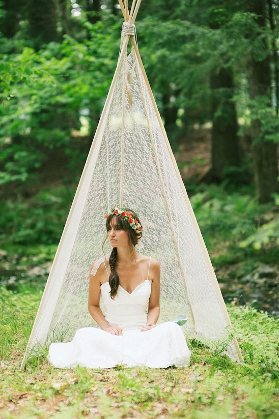 Bride in floral crown inside a lace teepee