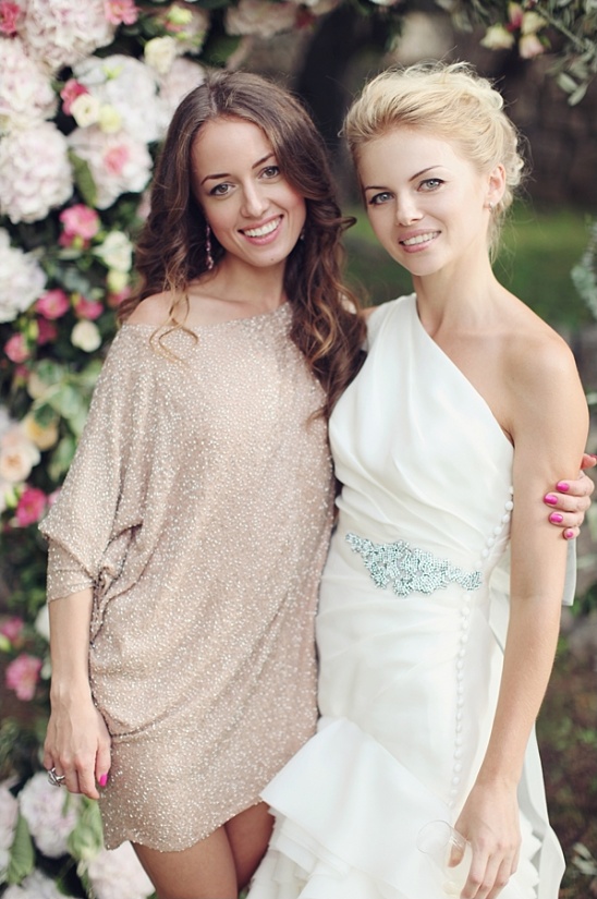 Two beautiful women smiling in front of a floral backdrop