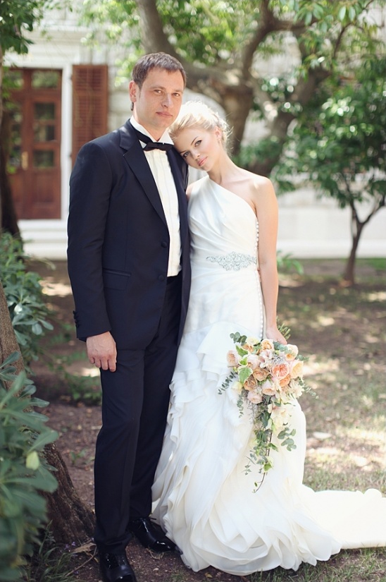 Elegant couple in wedding attire, smiling, outdoor photo
