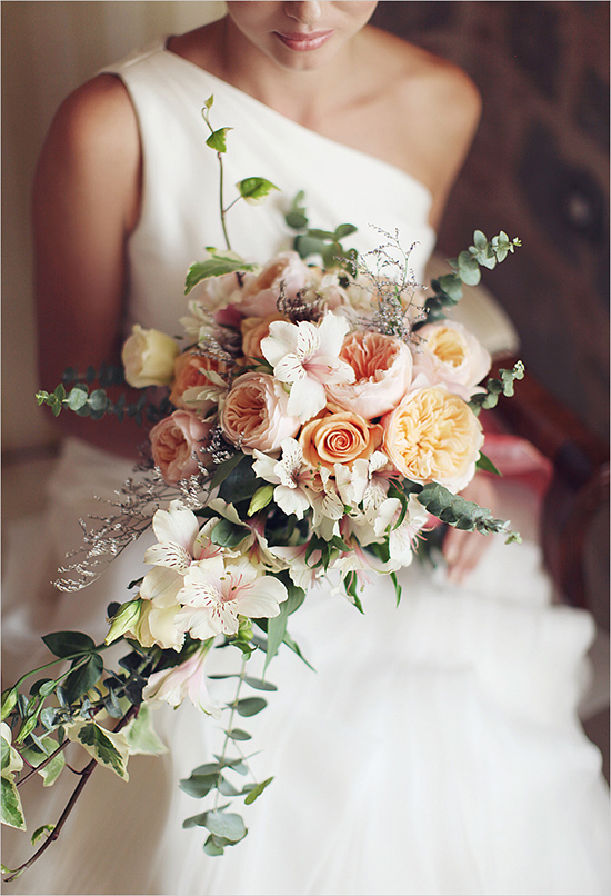 Bride holding a gorgeous cascading bouquet of pastel-colored flowers