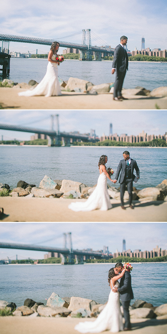 Wedding couple near the water, with the cityscape and bridge in background