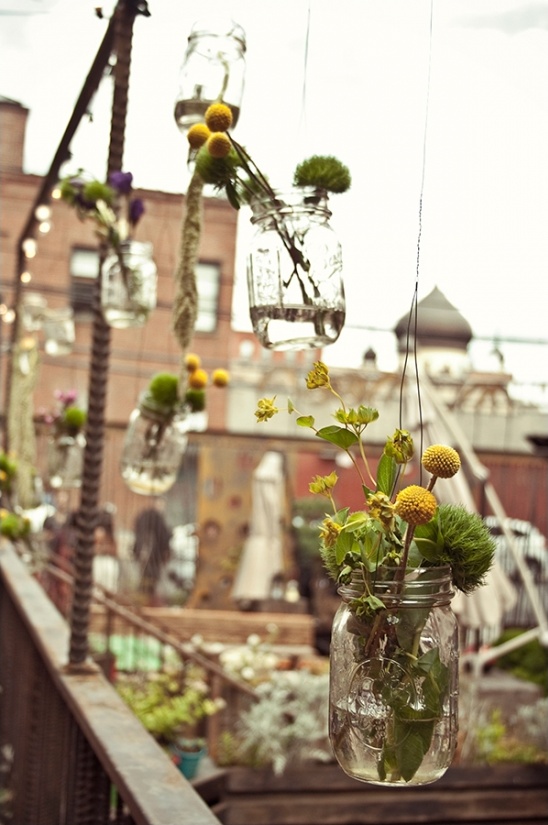 Hanging mason jars with flowers create a charming outdoor decoration