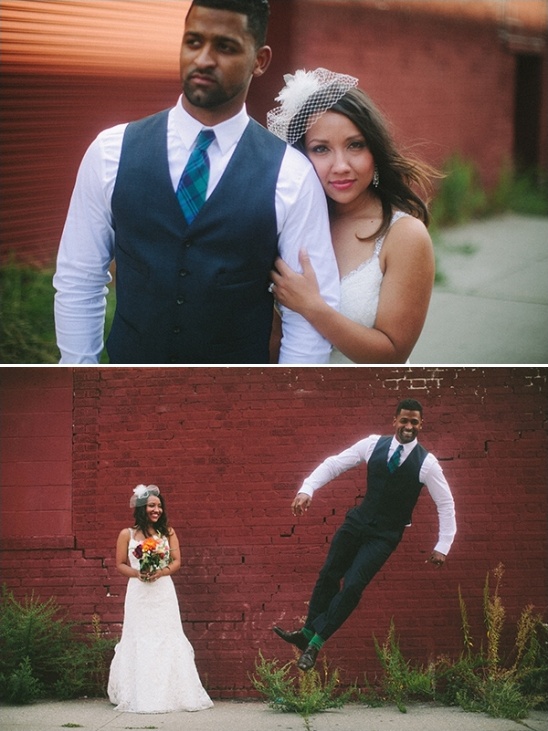 Joyful couple celebrating their wedding day in front of a red brick wall