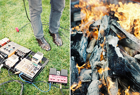 Guitar pedals on grass next to a roaring campfire with flames