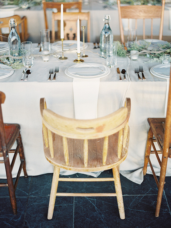 Rustic wedding table setting with wooden chairs and decor