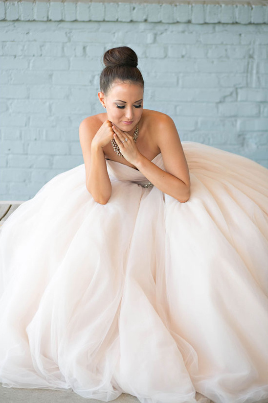 Bride in a stunning wedding dress looking thoughtful with elegant updo