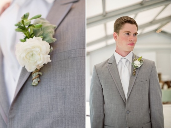 Groom in gray suit with white flower boutonniere