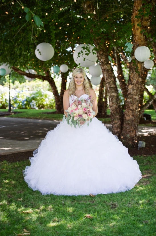 Bride in beautiful wedding dress under trees