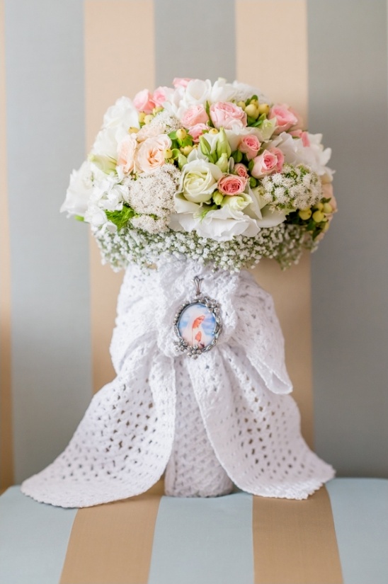 Beautiful bridal bouquet with pink and white flowers, adorned with a crochet wrap and locket