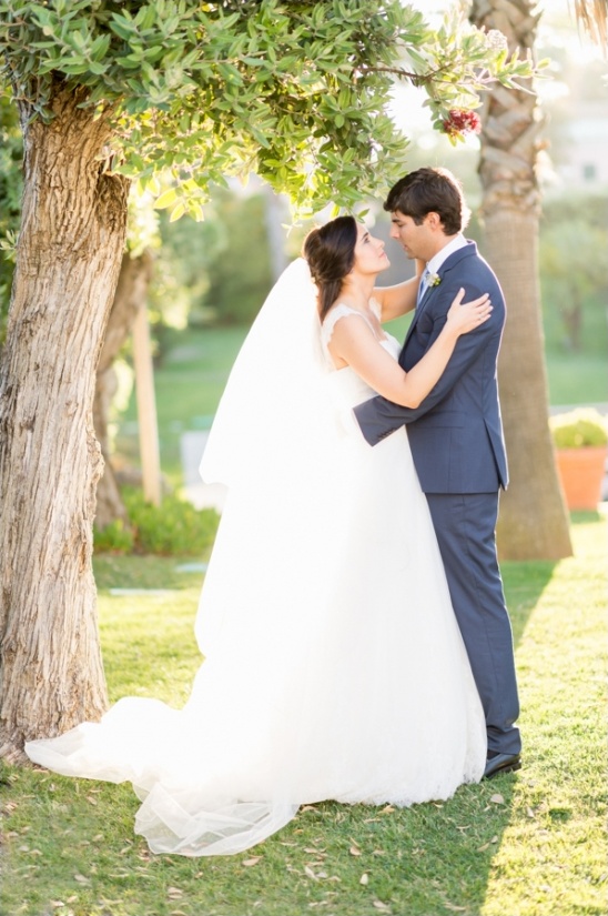 Bride and groom embracing under a tree, wedding day