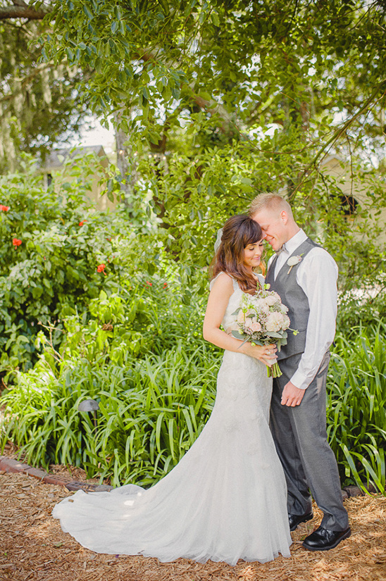 Bride and groom embrace in a lush garden wedding photo