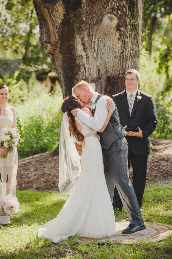 Newlyweds share their first kiss at outdoor wedding ceremony