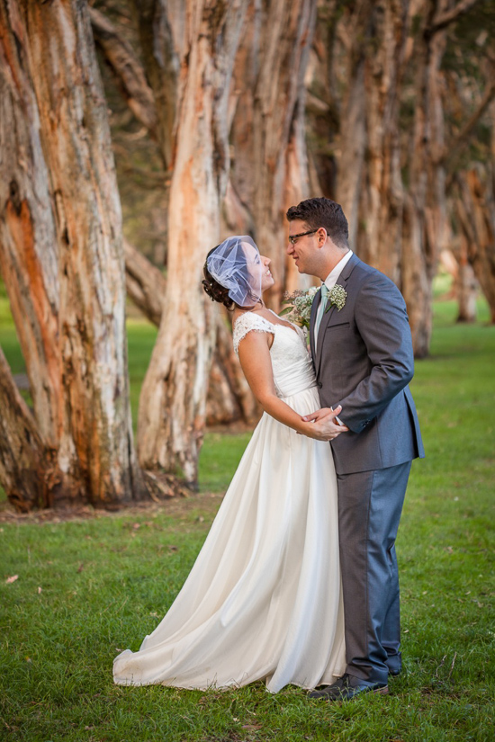 Newlyweds gaze lovingly at each other in a park setting
