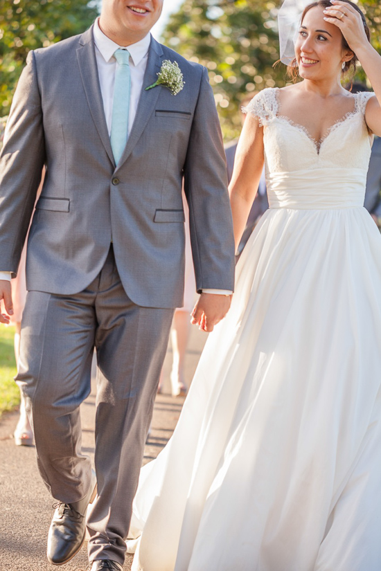 Happy bride and groom walking hand in hand at their wedding