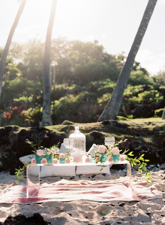 Beach picnic setting with floral decor and sunny ambiance