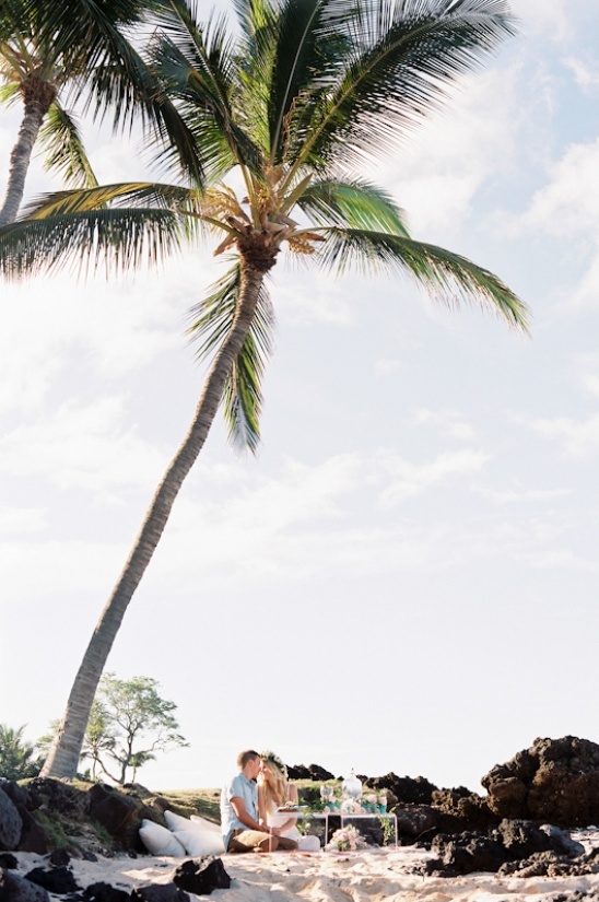 Couple kissing under palm tree on tropical beach