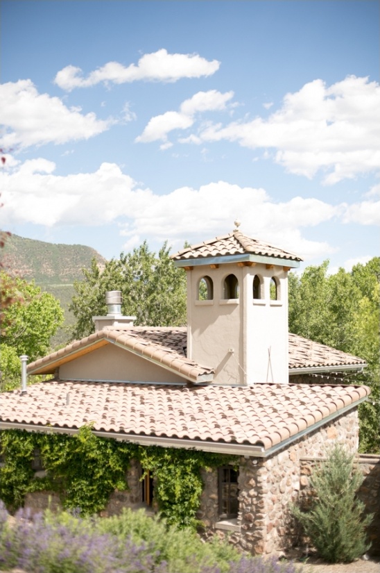 A charming stone house with a beautiful tiled roof under a sunny sky