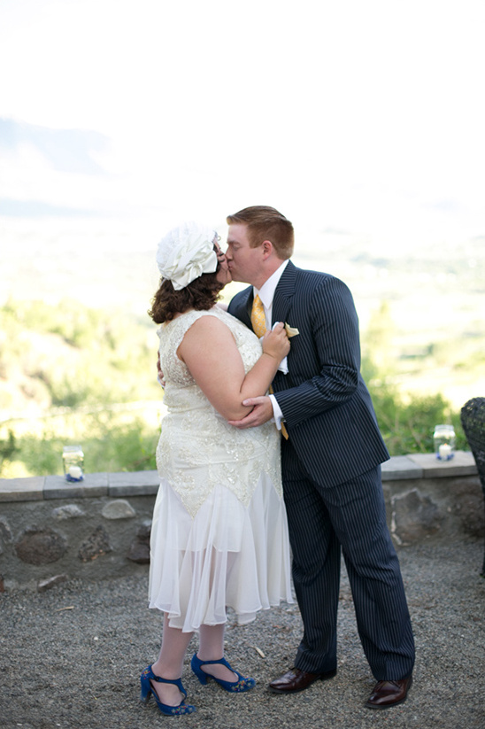 Happy couple kissing on their wedding day, elegant outdoor ceremony