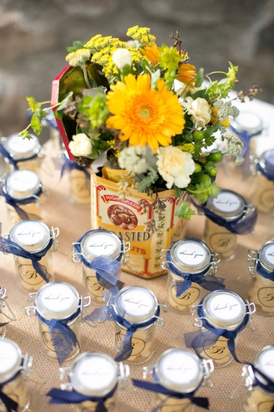 Wedding favors with flower arrangement on burlap table