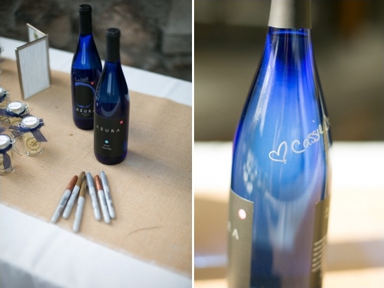 Blue Azura wine bottles with pens for guest signatures on a table