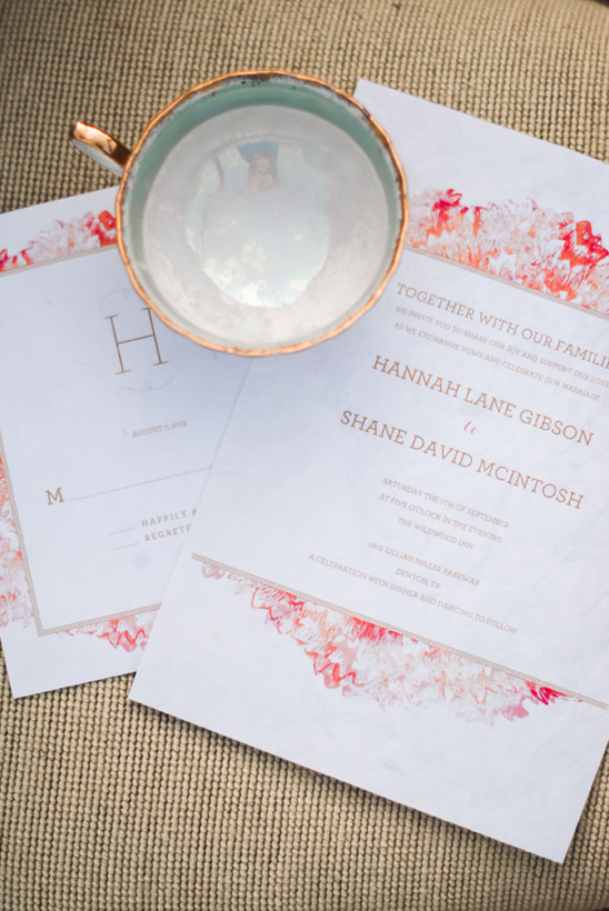 Elegant wedding invitations with a copper rimmed teacup on display