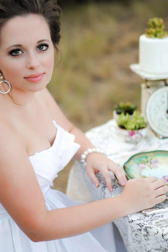 Beautiful woman in white dress smiles elegantly at tea party