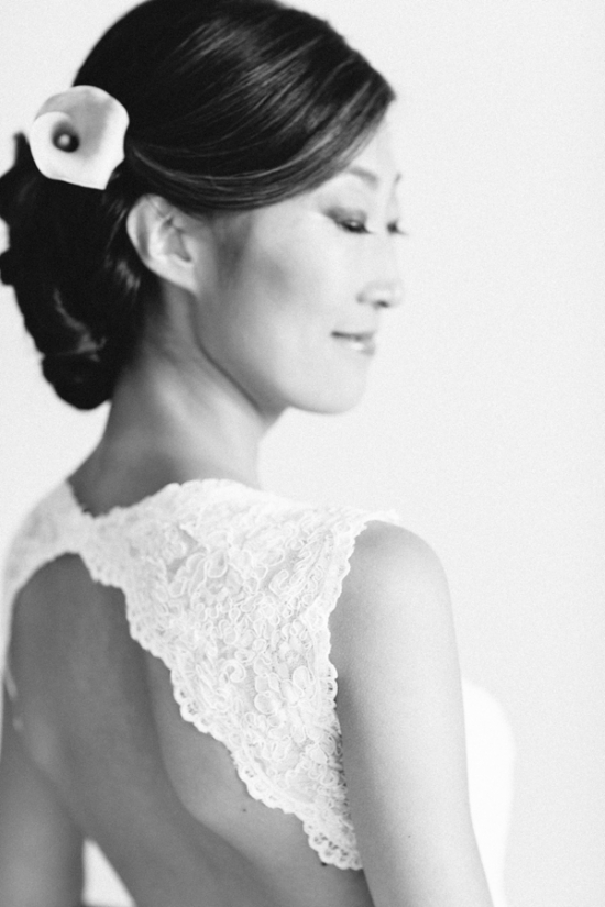 Elegant bride with flower, lace details, and serene expression