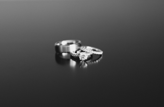 Elegant wedding rings on a dark reflective surface in black and white