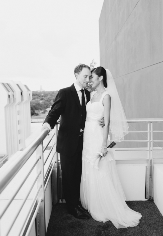 Newlyweds embrace on a balcony, black and white wedding photo
