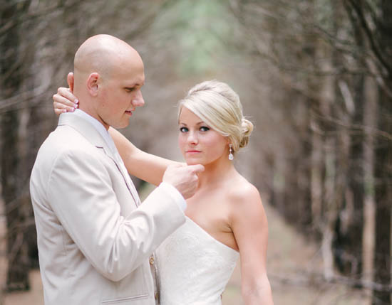 Bride and groom pose for a wedding photo in a forest