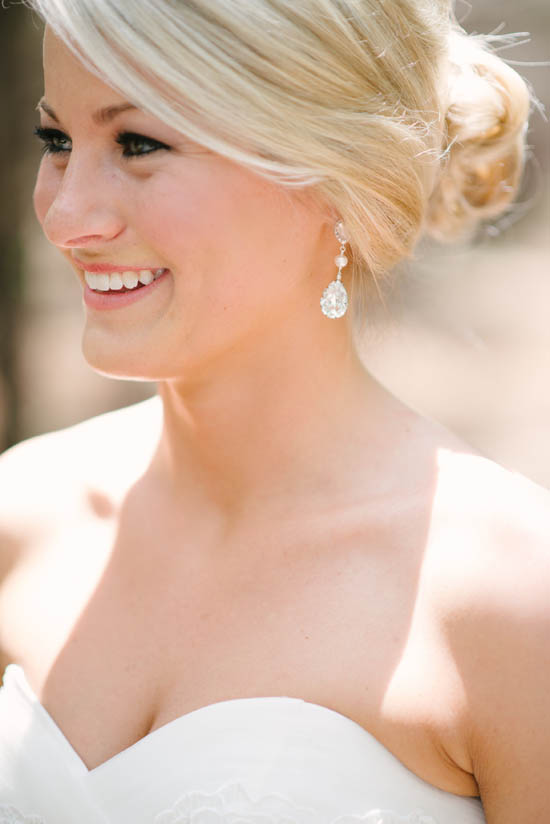 Beautiful bride smiling with elegant wedding earrings