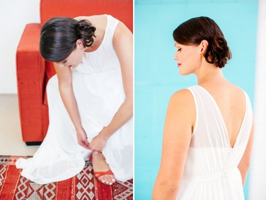 Bride adjusts her sandals on red rug before a photoshoot