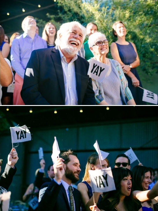 Guests celebrating with YAY flags at an outdoor event