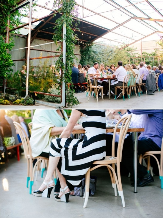Outdoor wedding reception with people at tables under a glass roof