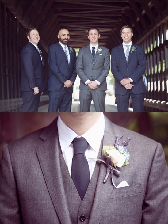 Groomsmen in stylish suits posing in a wooden tunnel at a wedding