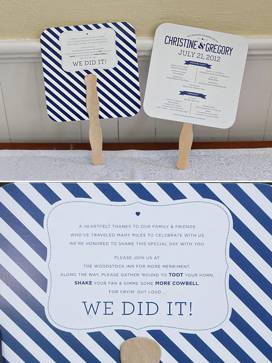 Wedding fans with navy stripes and wedding details displayed