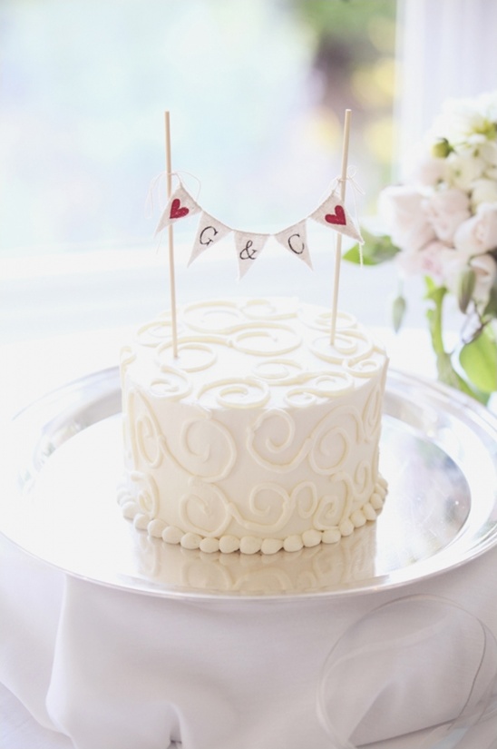 Elegant white wedding cake with initials and heart accents on top